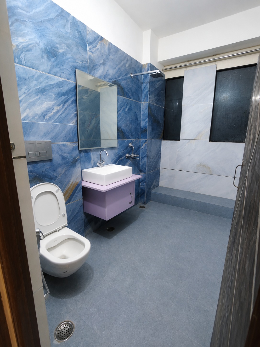 Premium bathroom in blue marble-effect tile with a rain shower